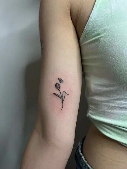 Fine line purple tulip and butterfly in colour on the arm