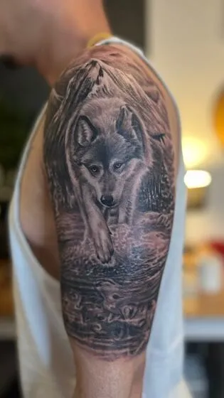 Realism wolf wading through a stream on the upper arm