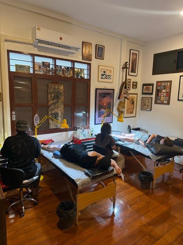 The tattoo room with wooden floors, shutters and framed art